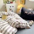 Pillowcases with matching black and white stripes beside cozy desk lamp