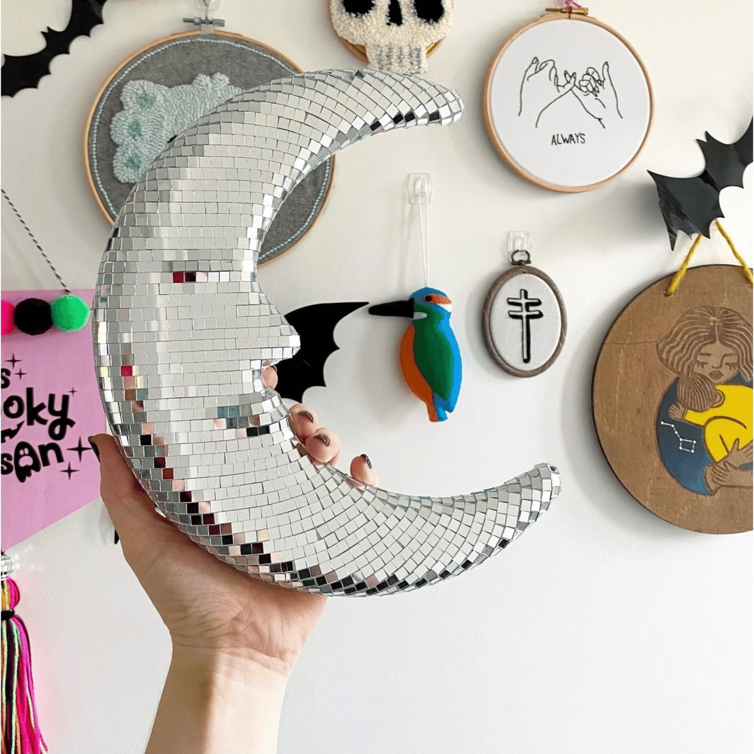 Disco moon pendant reflecting sparkles on white wall