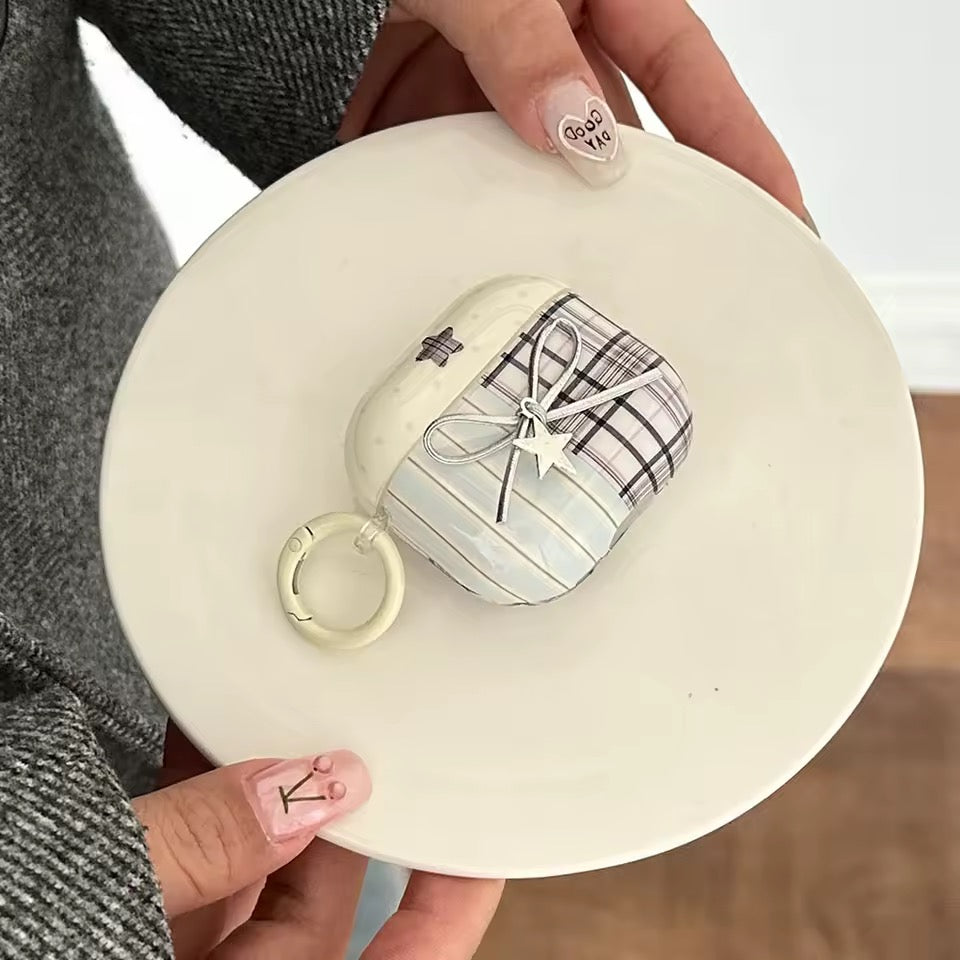 Small checkered bag with a ring held by a person on a white surface
