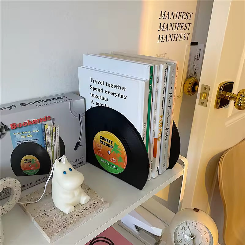 Decorative shelf with books, record, and small figurine near a door.