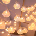 String of shell-shaped fairy lights against a blurred indoor background