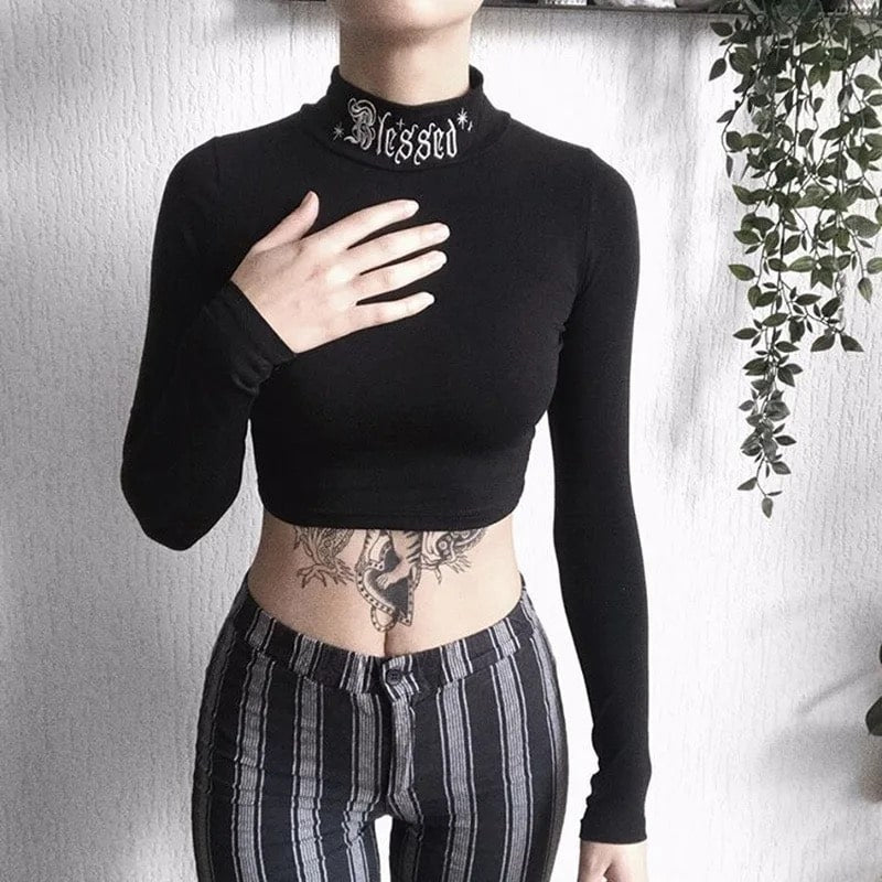 Black witchy crop top with Gothic letter embroidery. Long sleeve bodycon turtleneck design perfect for Harajuku and Y2K aesthetics.