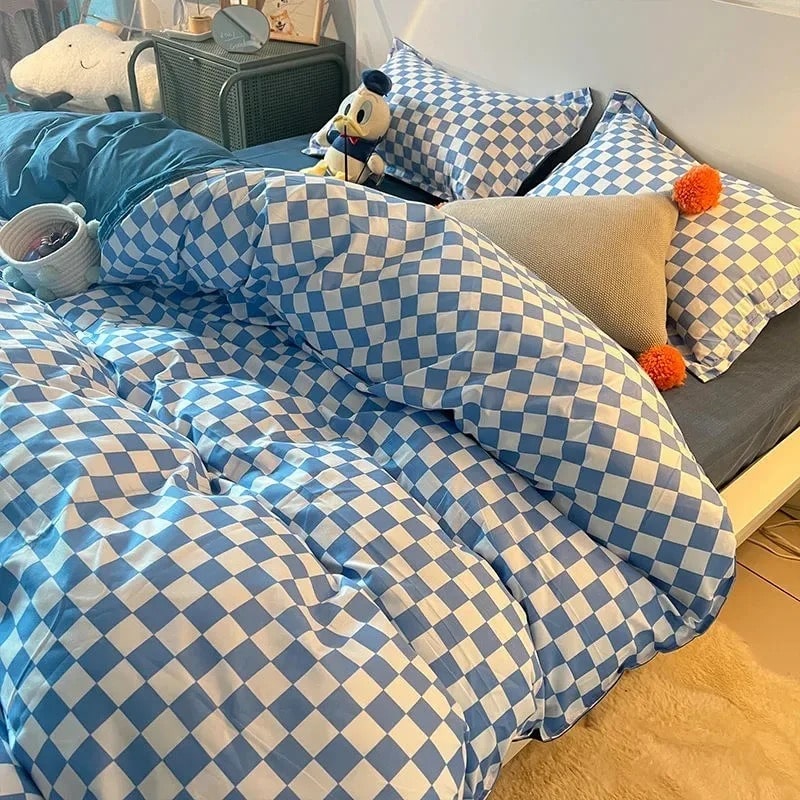Blue checkerboard bedding set styled on a bed with matching pillowcases