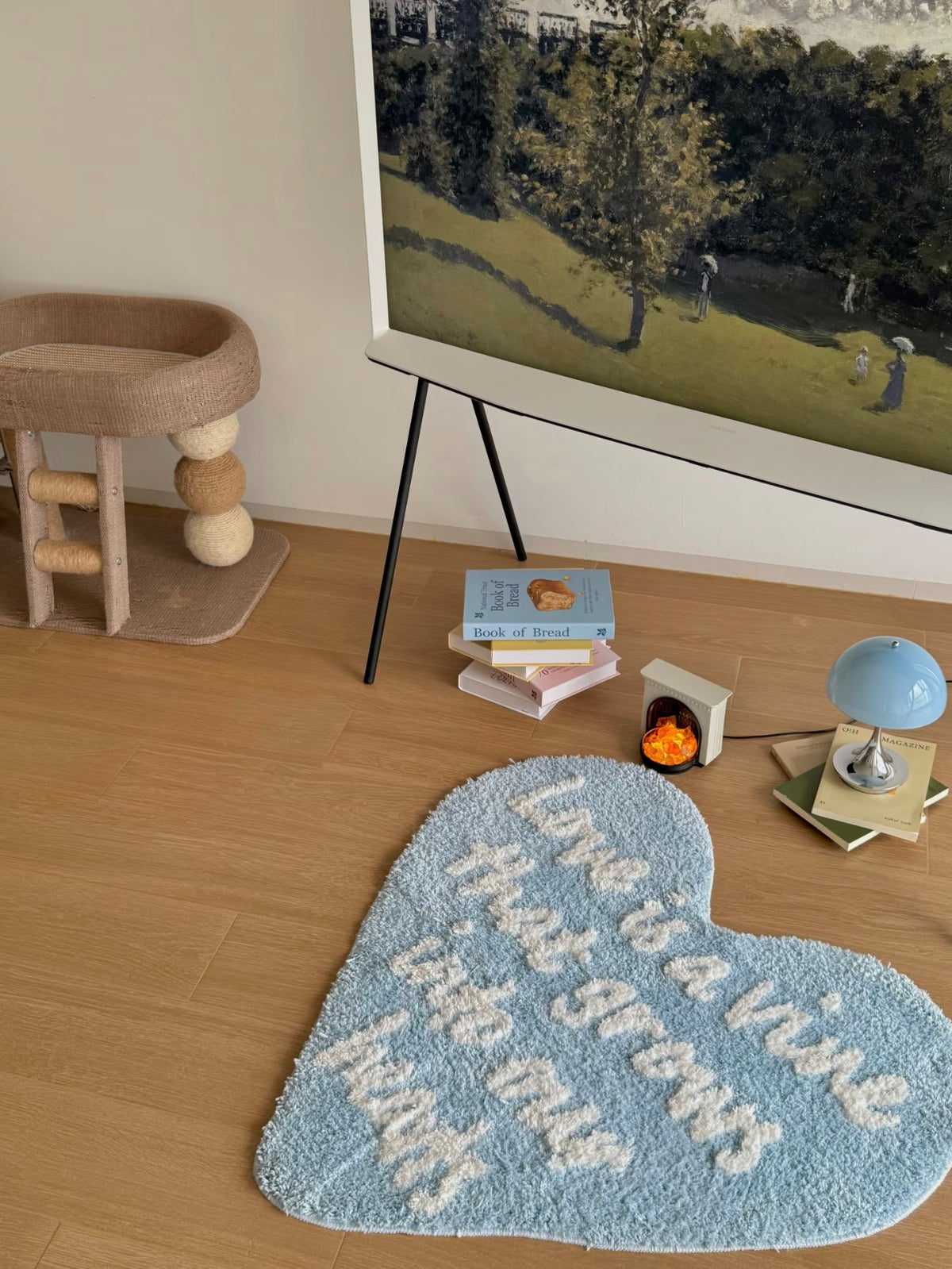 Blue heart rug with white script lies below a screen, adding a heart outline to an open patch of floor.
