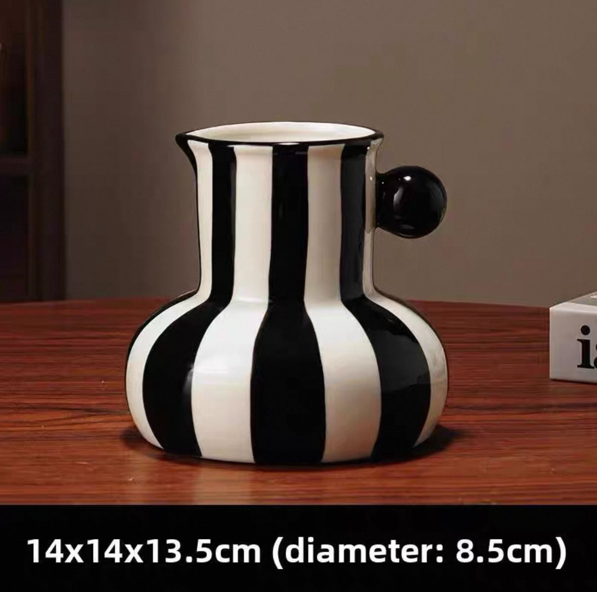 Black and white striped vase on a wooden surface with dimensions displayed.