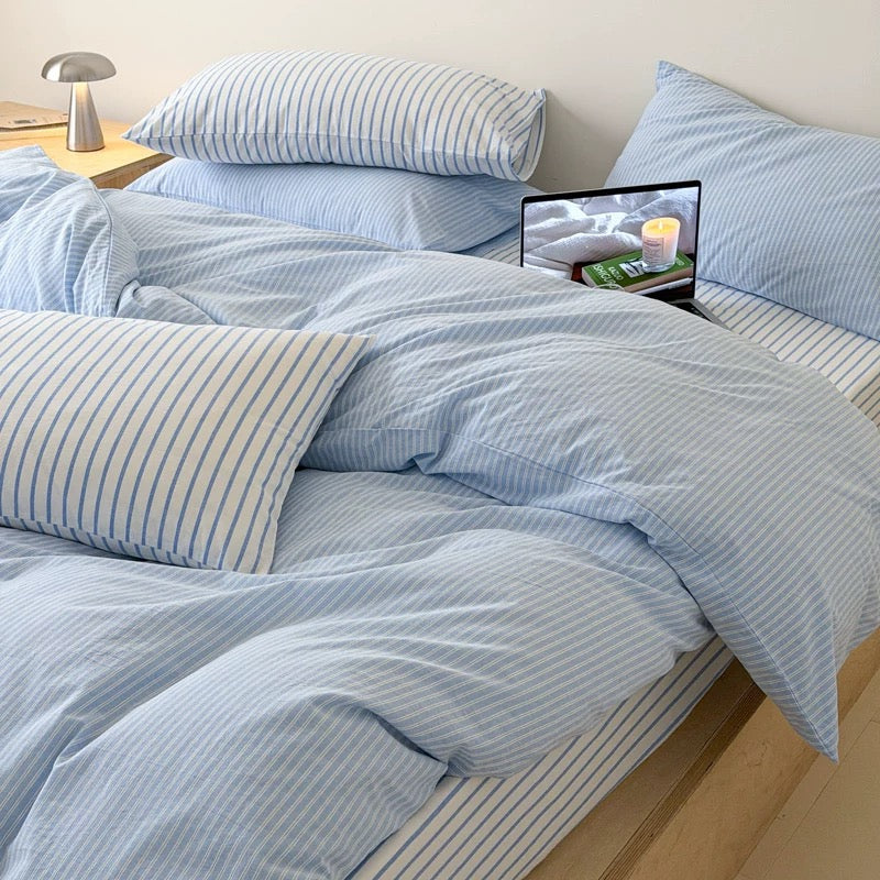 Coastal inspired light blue cotton duvet cover adding fresh color and delicate striped pattern to modern bedroom.