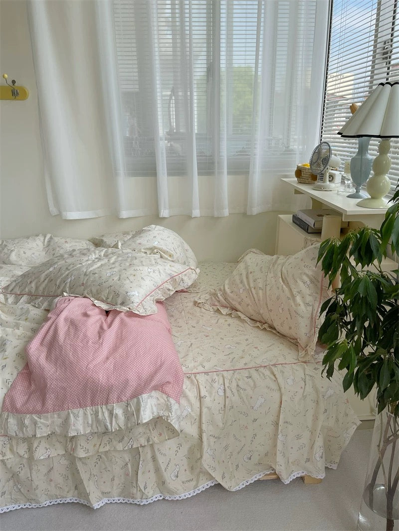 Cream bunny print cotton bedding set with ruffle edges styled in cozy coquette aesthetic bedroom interior.