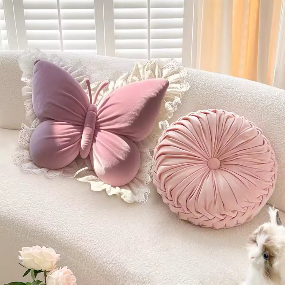 Pink butterfly and round pillow on a white sofa with floral decorations.