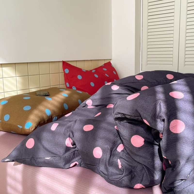 Dark polka dot duvet cover with pink accents styled for cozy teen girl bedroom