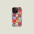 Close-up of the checkered flower iPhone case featuring bold retro grid design in red, green, pink, and blue