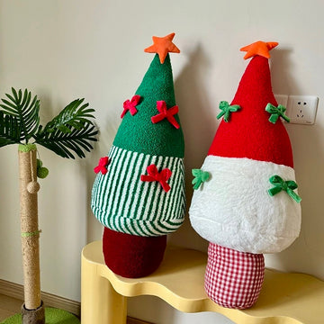 Red and green Christmas tree pillows beside seasonal room decor