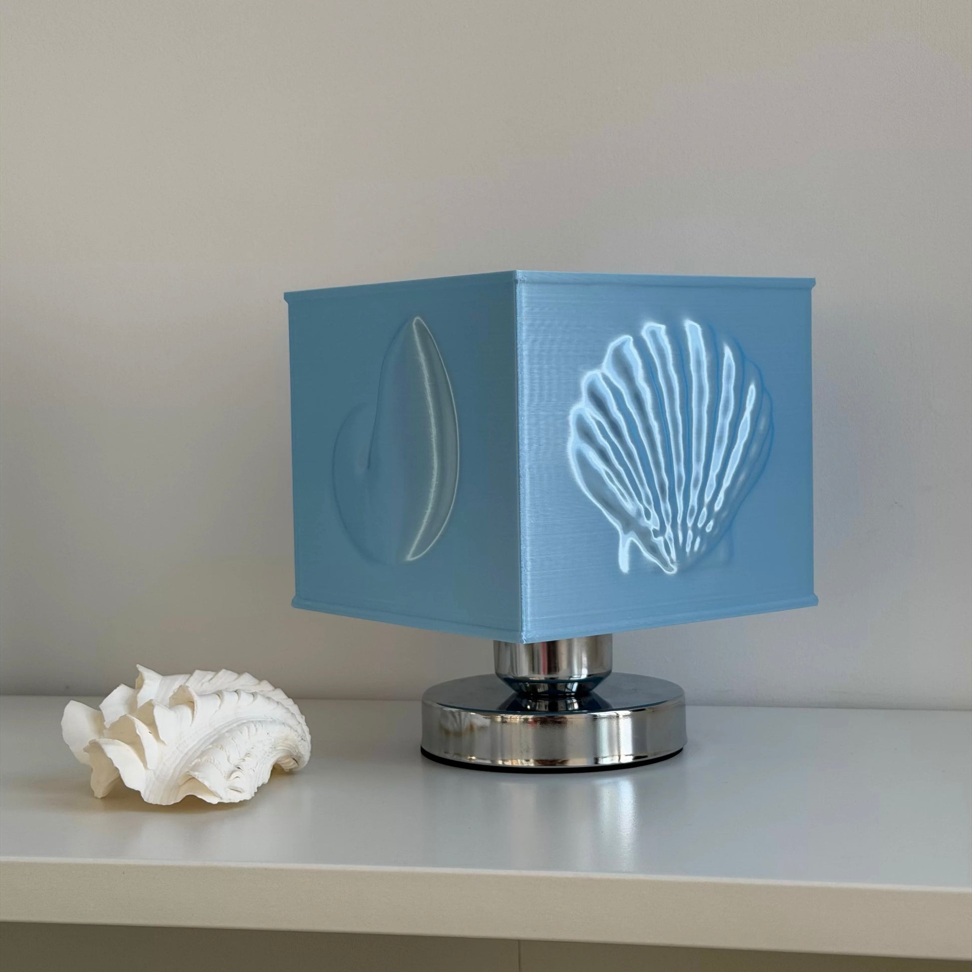 Blue seashell relief bedside lamp styled for aesthetic coastal inspired bedroom interiors
