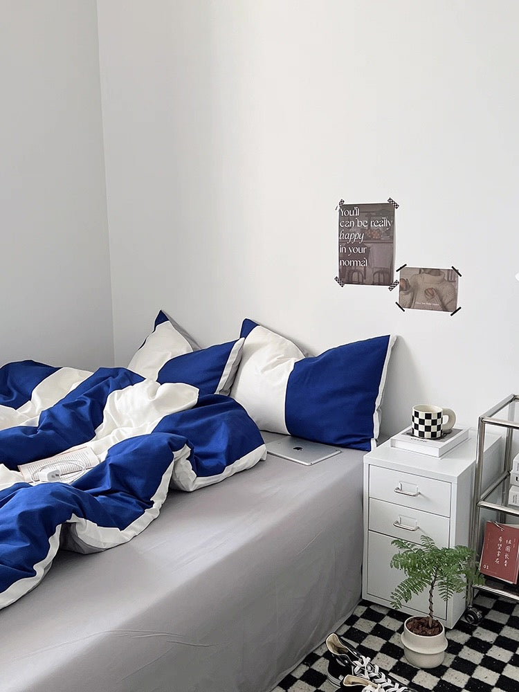 Bedroom with blue and white bedding, nightstands, and decorative items.
