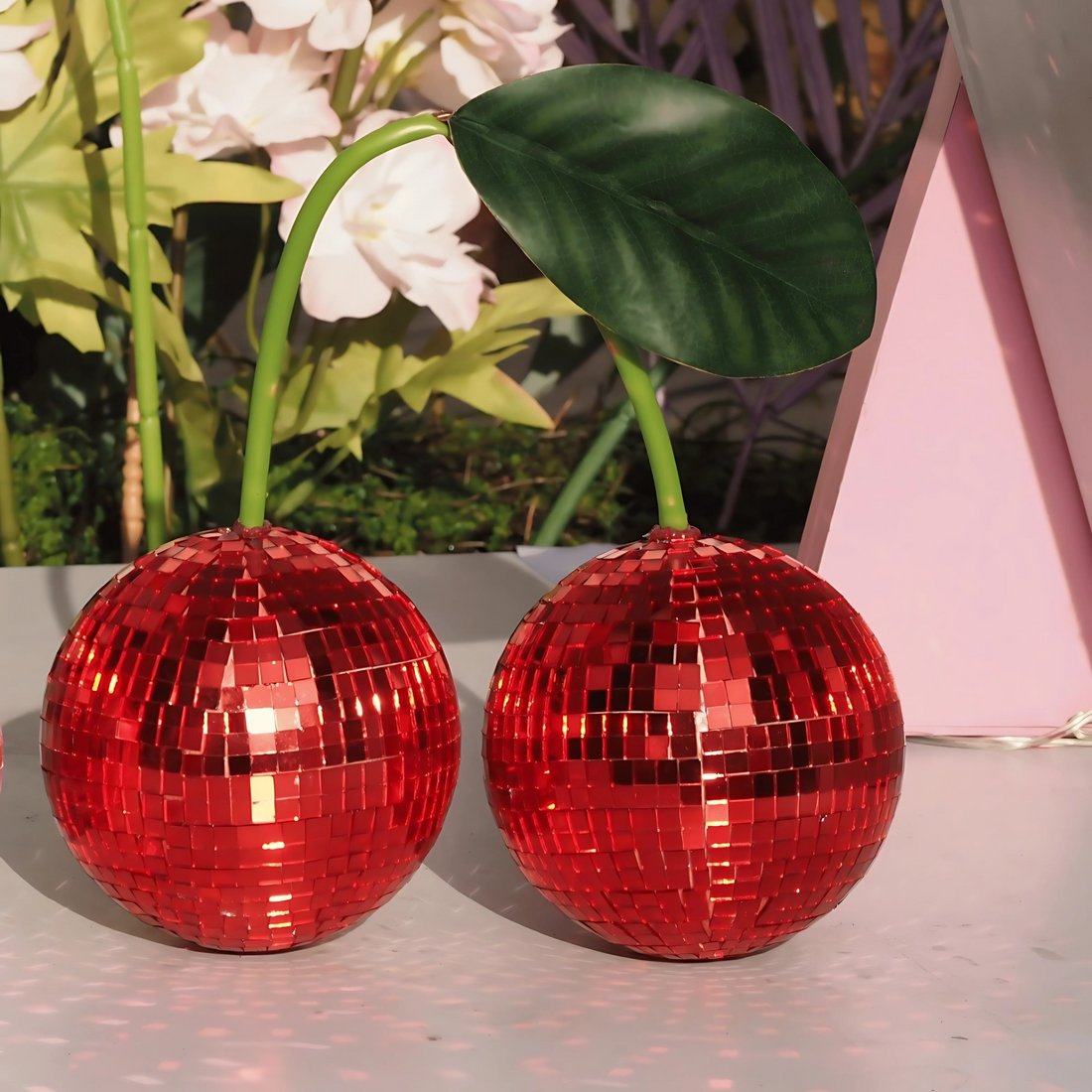 Red cherry disco ball set on shelf sparkling in sunlight