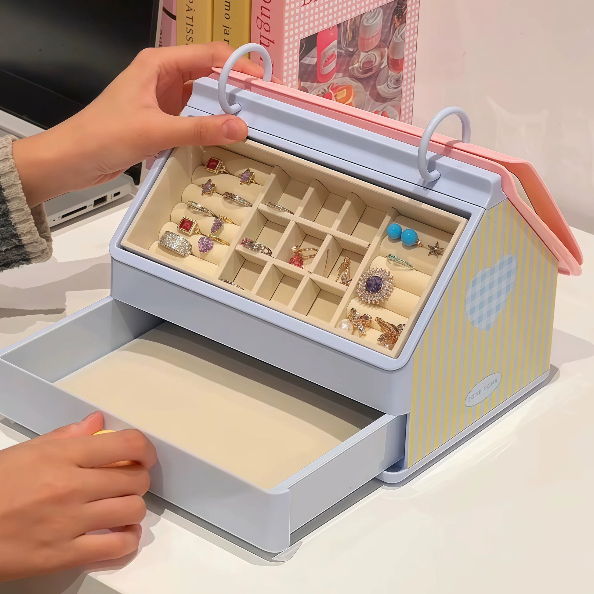 Jewelry box with jewelry inside, held open by a hand on a light background