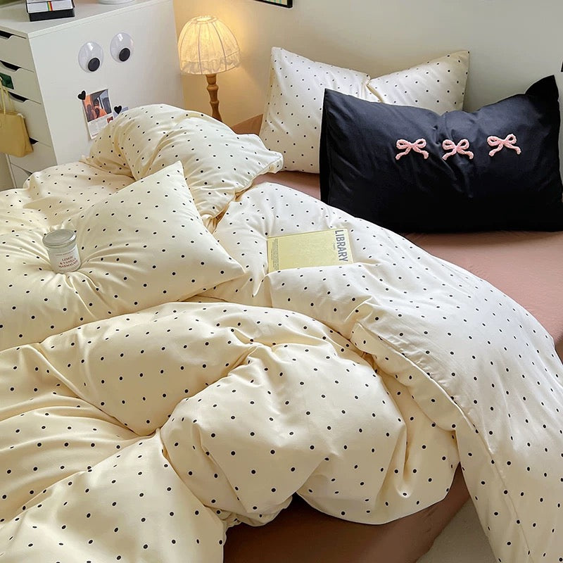 Overhead view of aesthetic brown bedding with black dots and pastel accessories, perfect for a coquette room setup