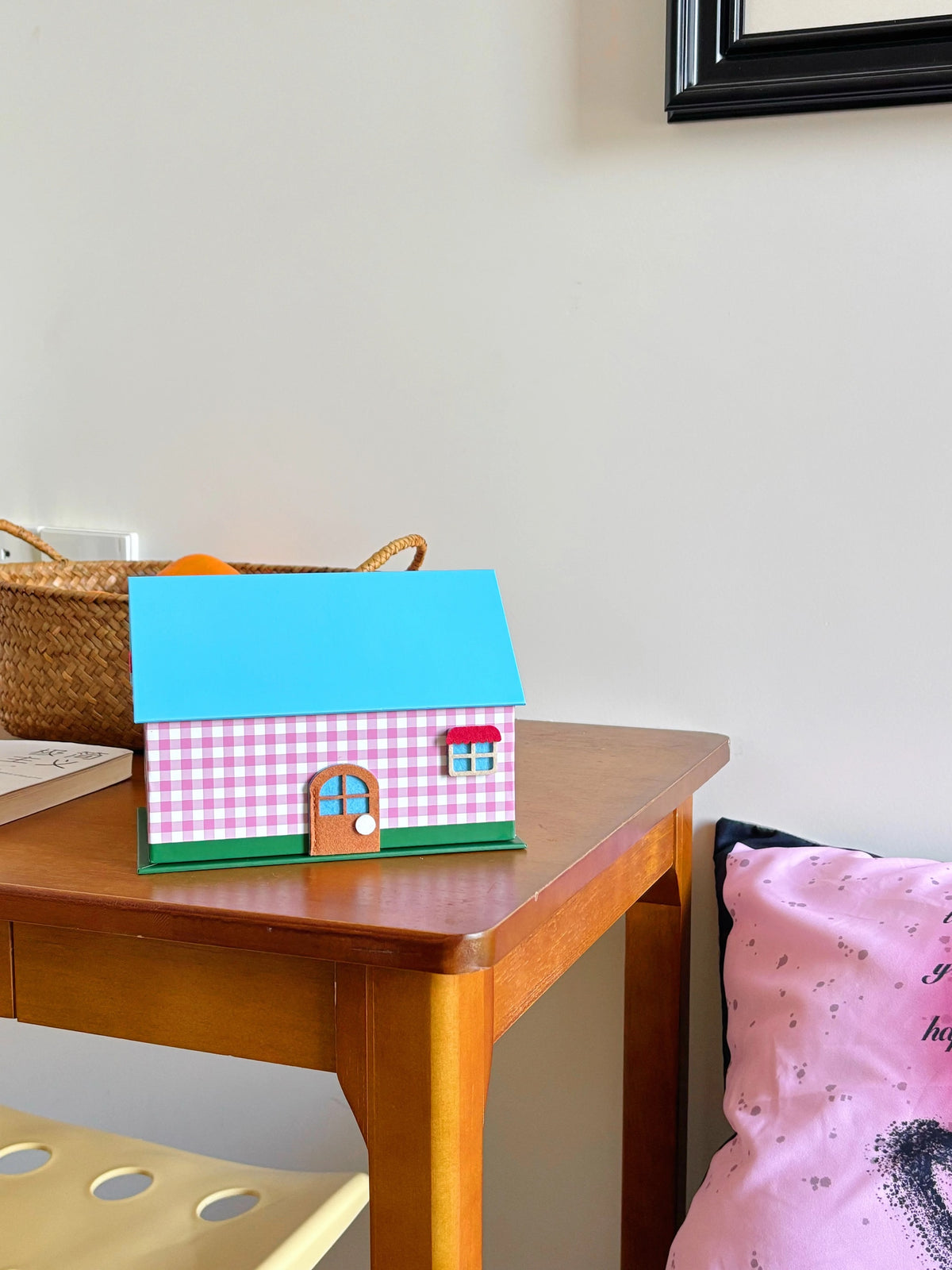 Pink gingham tissue box cover on a wooden side table