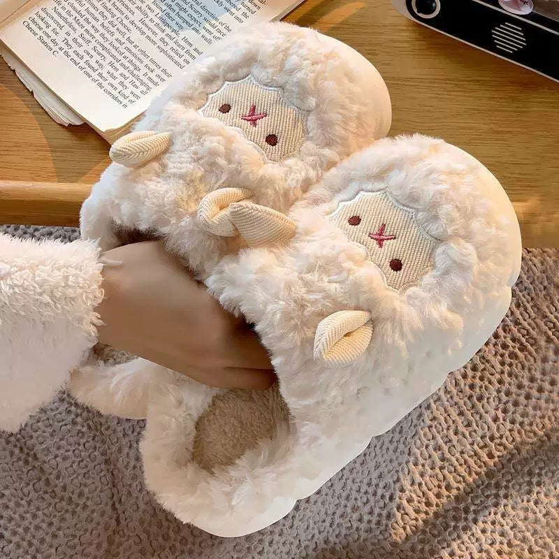 White fluffy slippers with cartoon face design worn by a person on a textured surface.