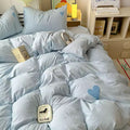 Blue heart comforter and pillows arranged in a cloudcore-inspired dorm room