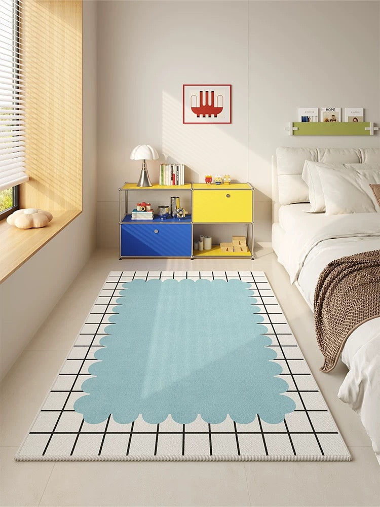 Modern bedroom with a blue patterned rug, colorful storage unit, and a bed.