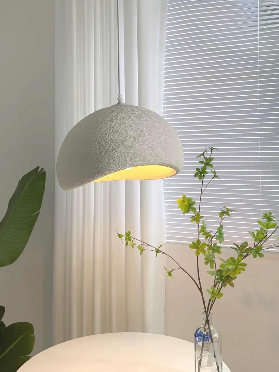 Gray dome pendant lamp in living room with blinds and curtains


