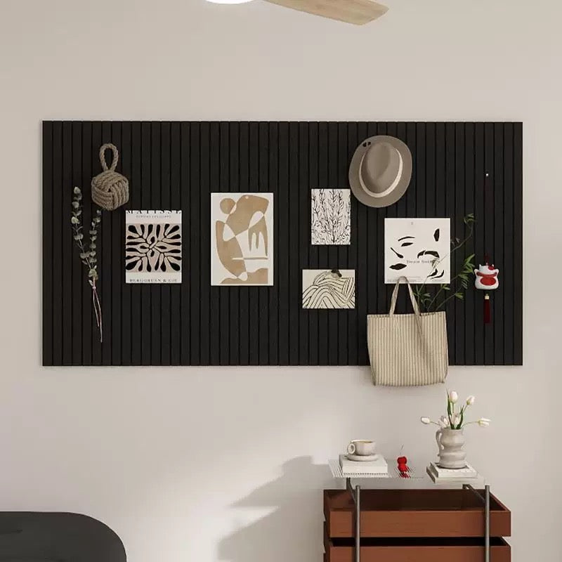 Black textured wall panel with decorative items on a white wall.