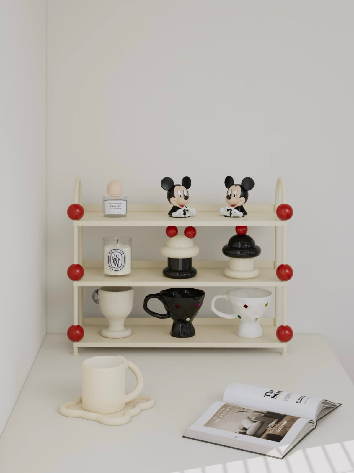 Cream display shelf with red ball details holds small figures and bottles across its three open levels.