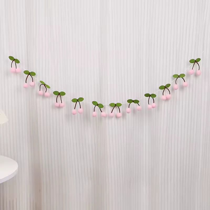 Decorative garland with pink berries and green leaves on a textured wall.