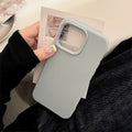Gray phone case held by a person with a magazine in the background