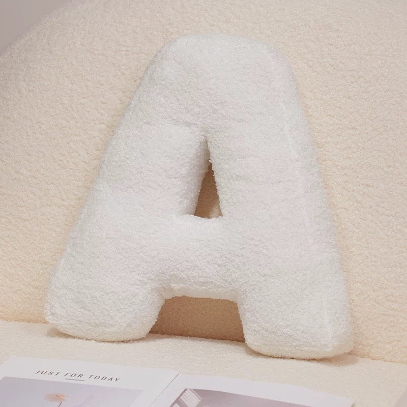 White letter 'A' pillow on a beige background