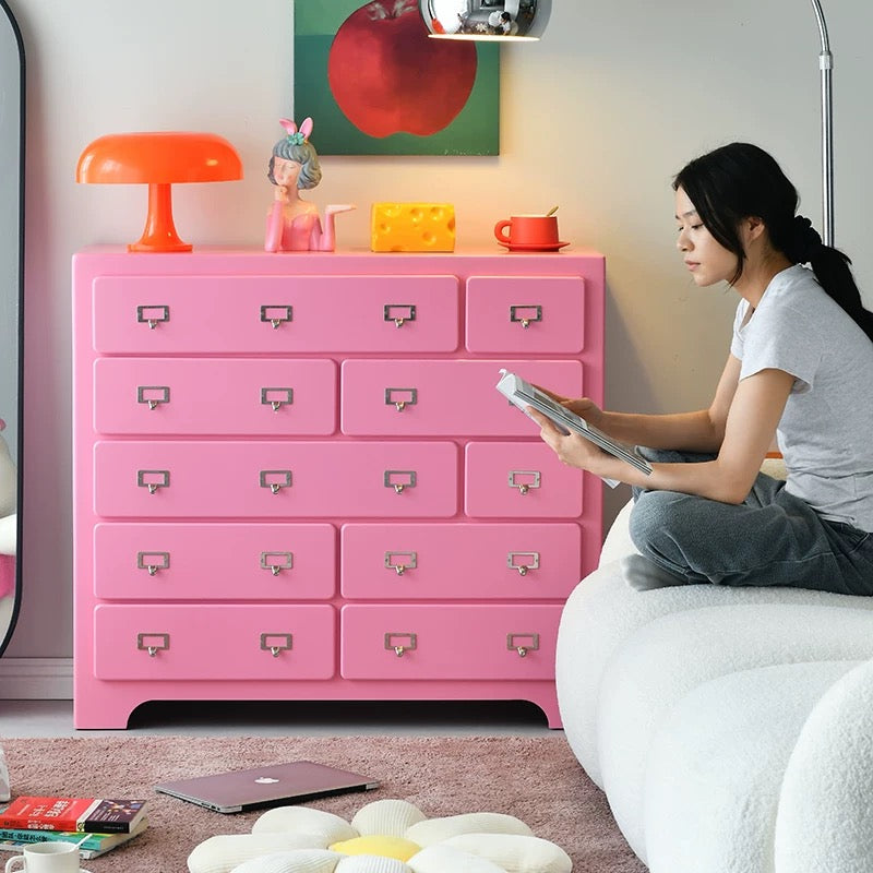 Pink dopamine storage cabinet with multiple drawers used in pastel themed room interior