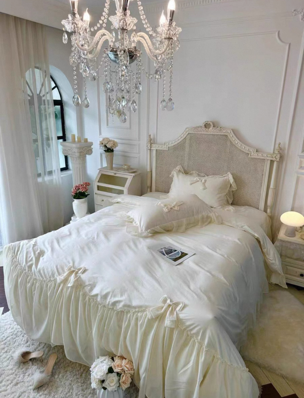Neatly made bed in a bedroom with a chandelier and decorative elements.
