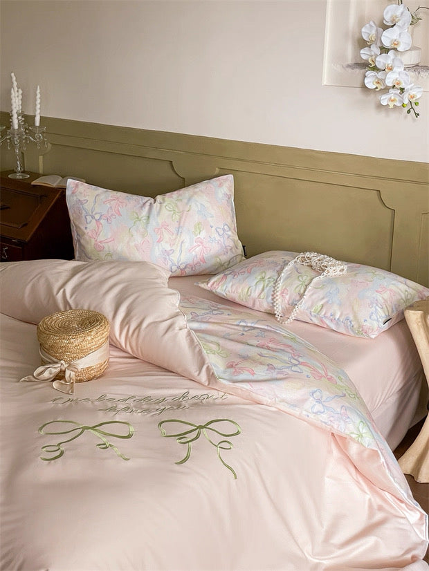 Neatly made bed with floral bedding and pillows in a bedroom setting.