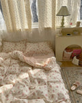 Pink floral lace ruffle duvet laid on sunlit bed showing delicate embroidery detail