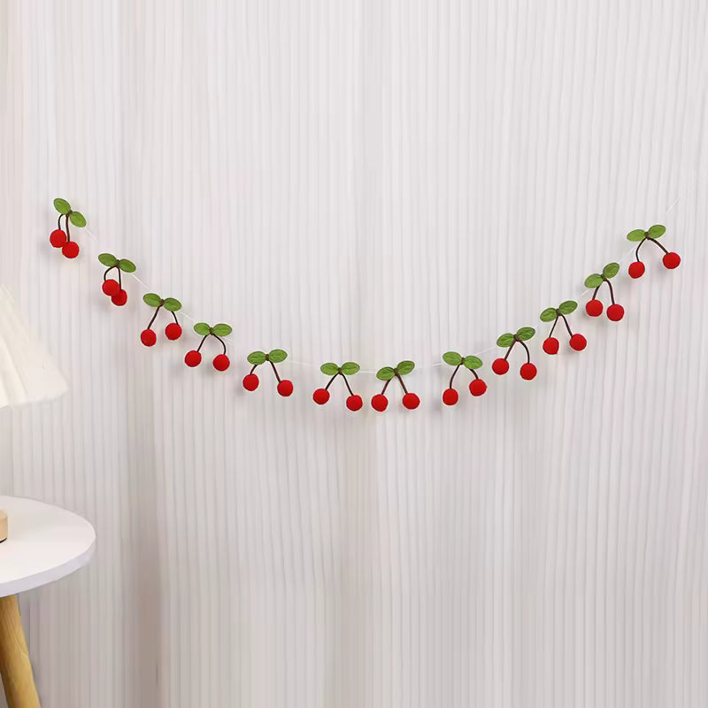 Decorative garland with red berries and green leaves on a white textured wall.