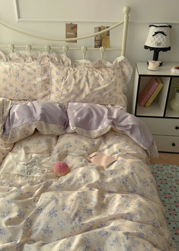 Bed with floral bedding and pillows in a bedroom setting.