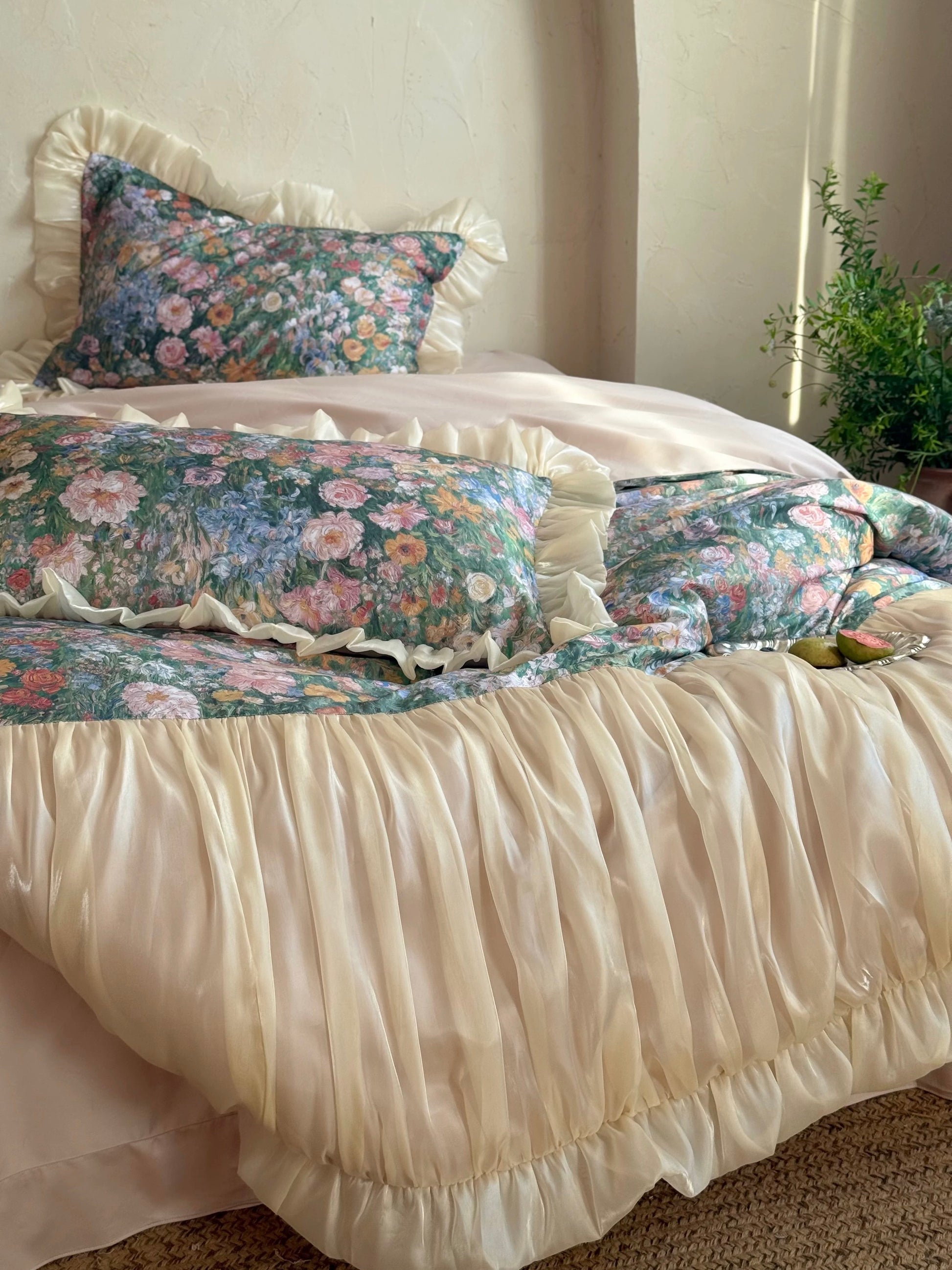 Floral bedding set with ruffled bedskirt on a bed in a bedroom.