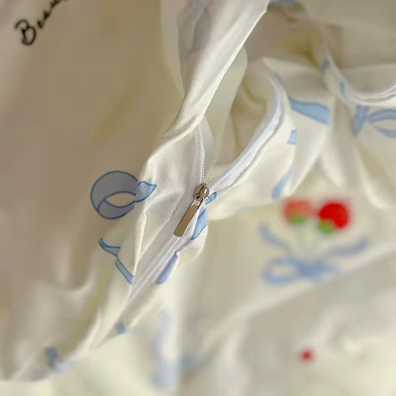 Pastel cherry bow bedding arranged with pink pillows in a soft girl aesthetic setup.