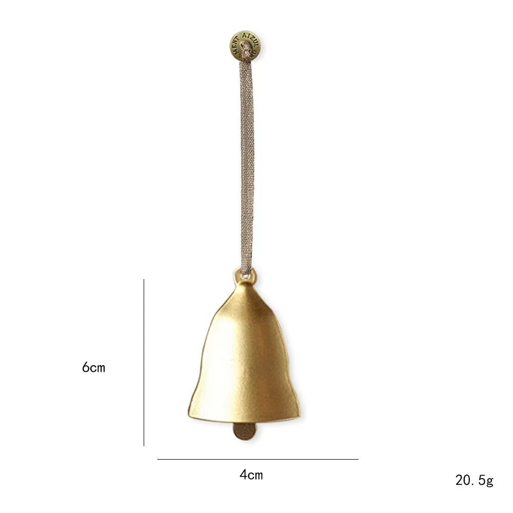 A gold bell metal Christmas ornament has a rounded top, flared lower edge and a visible hanging clapper.