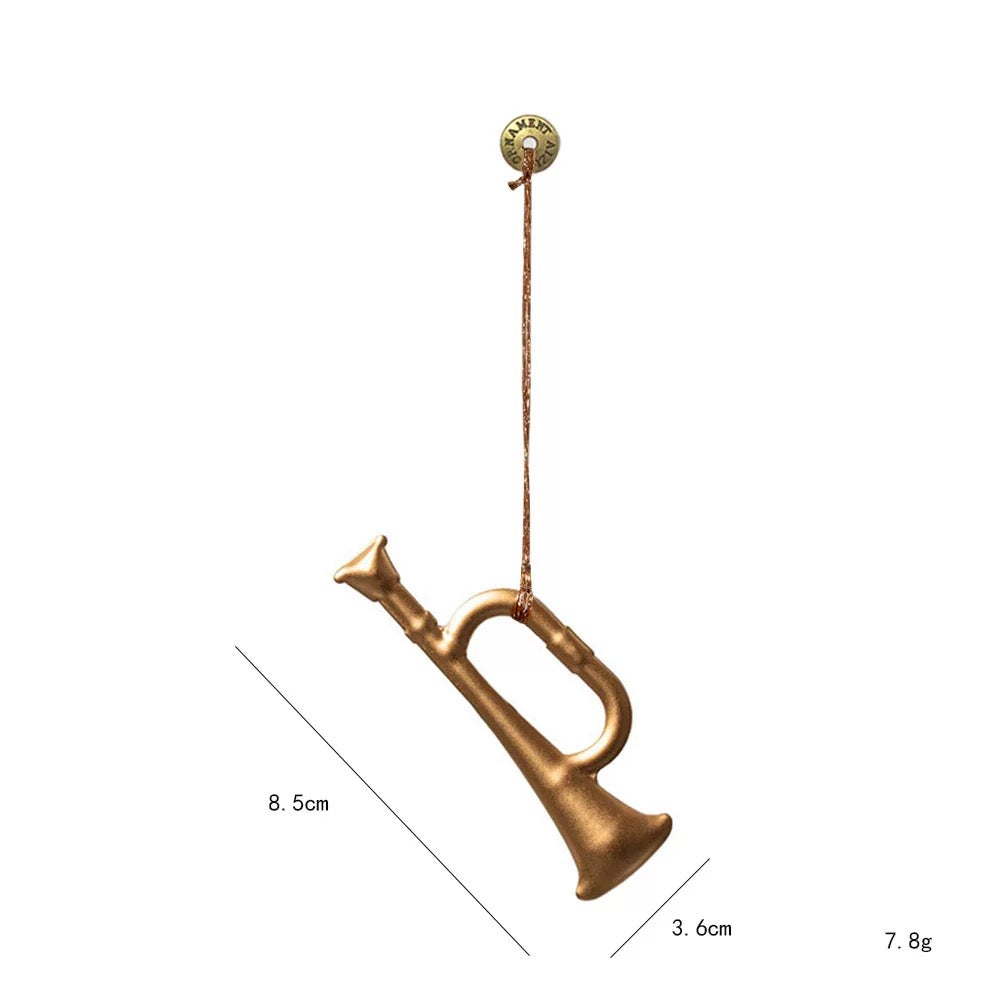 A gold trumpet Christmas tree ornament has a curved tube, flared bell and a hanging cord tied at the top.