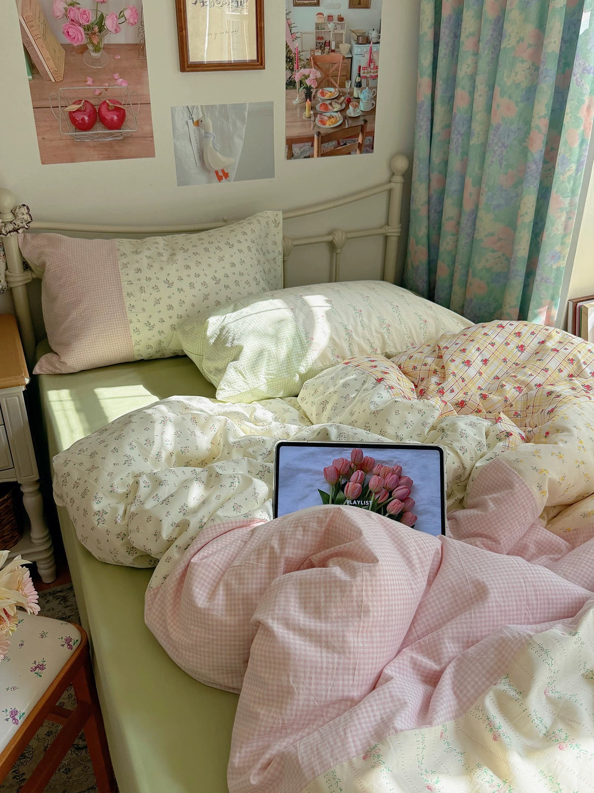 Green floral patchwork bedding with pink gingham on a cream bed
