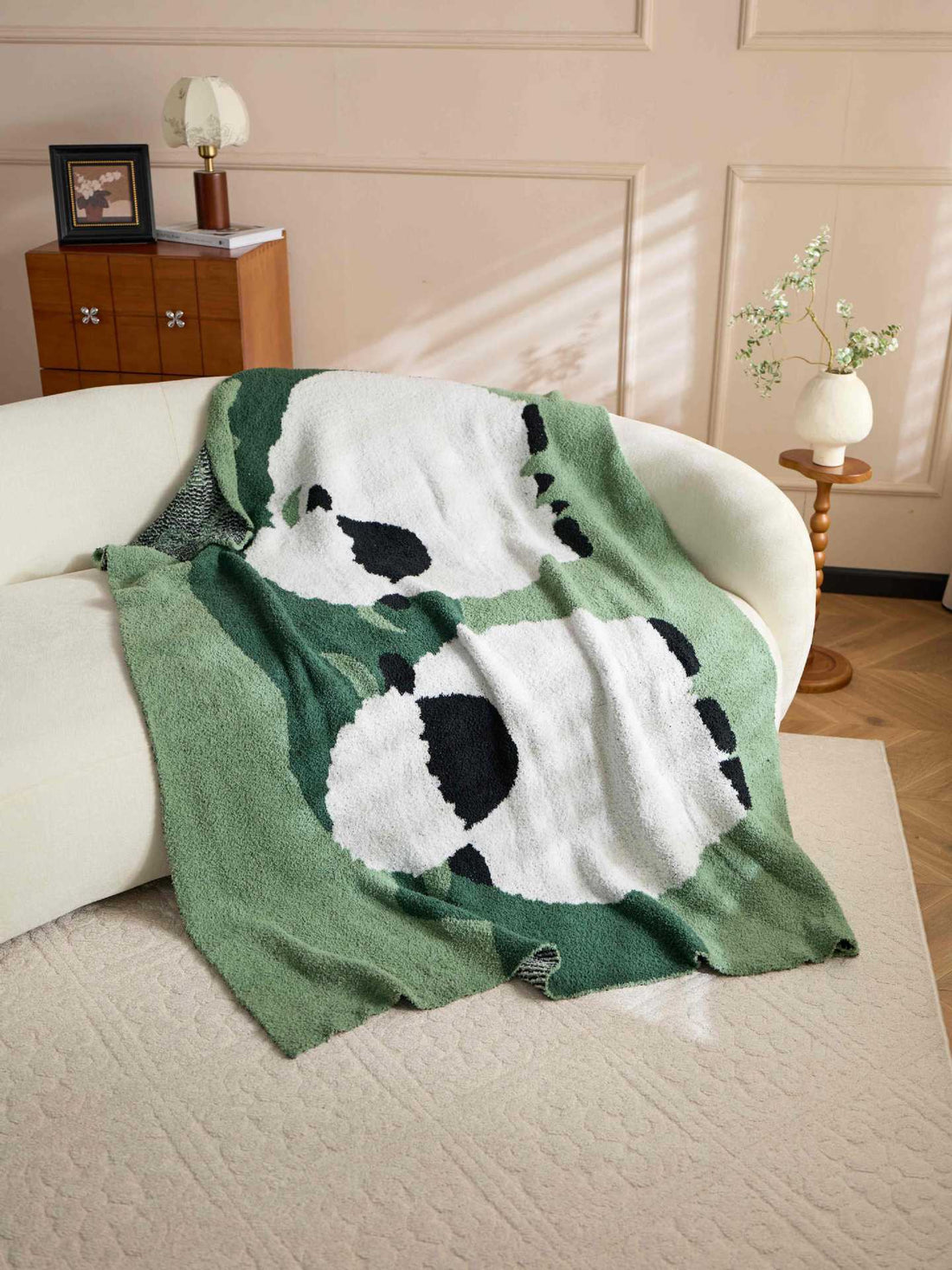 Light green sides and a green center surround the white sheep on a plush throw.