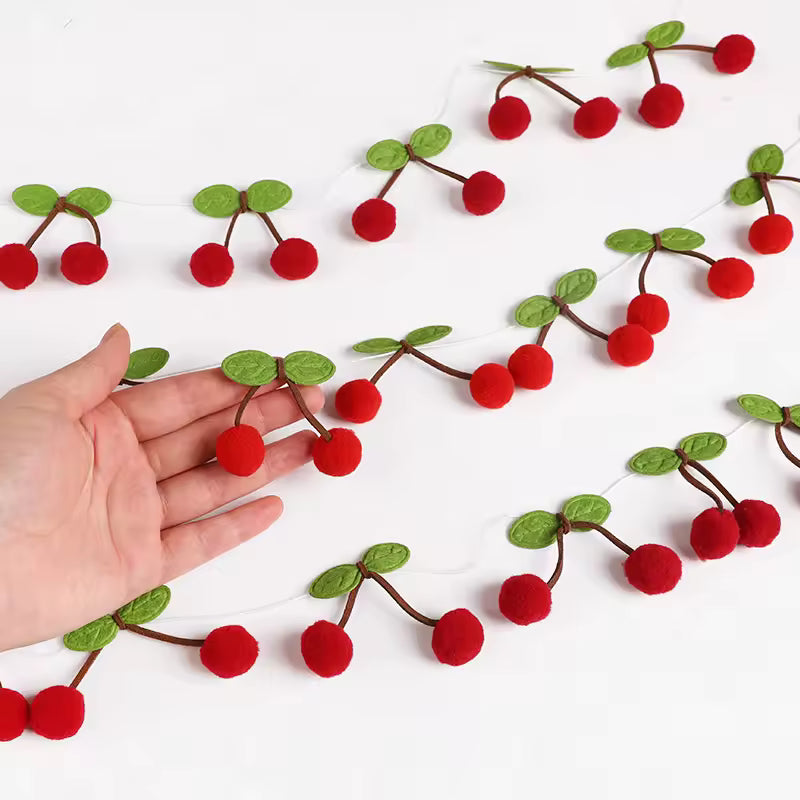 Decorative garland with red berries and green leaves on a white textured wall.