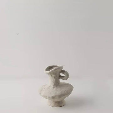 Small gray ceramic vase on a light gray background