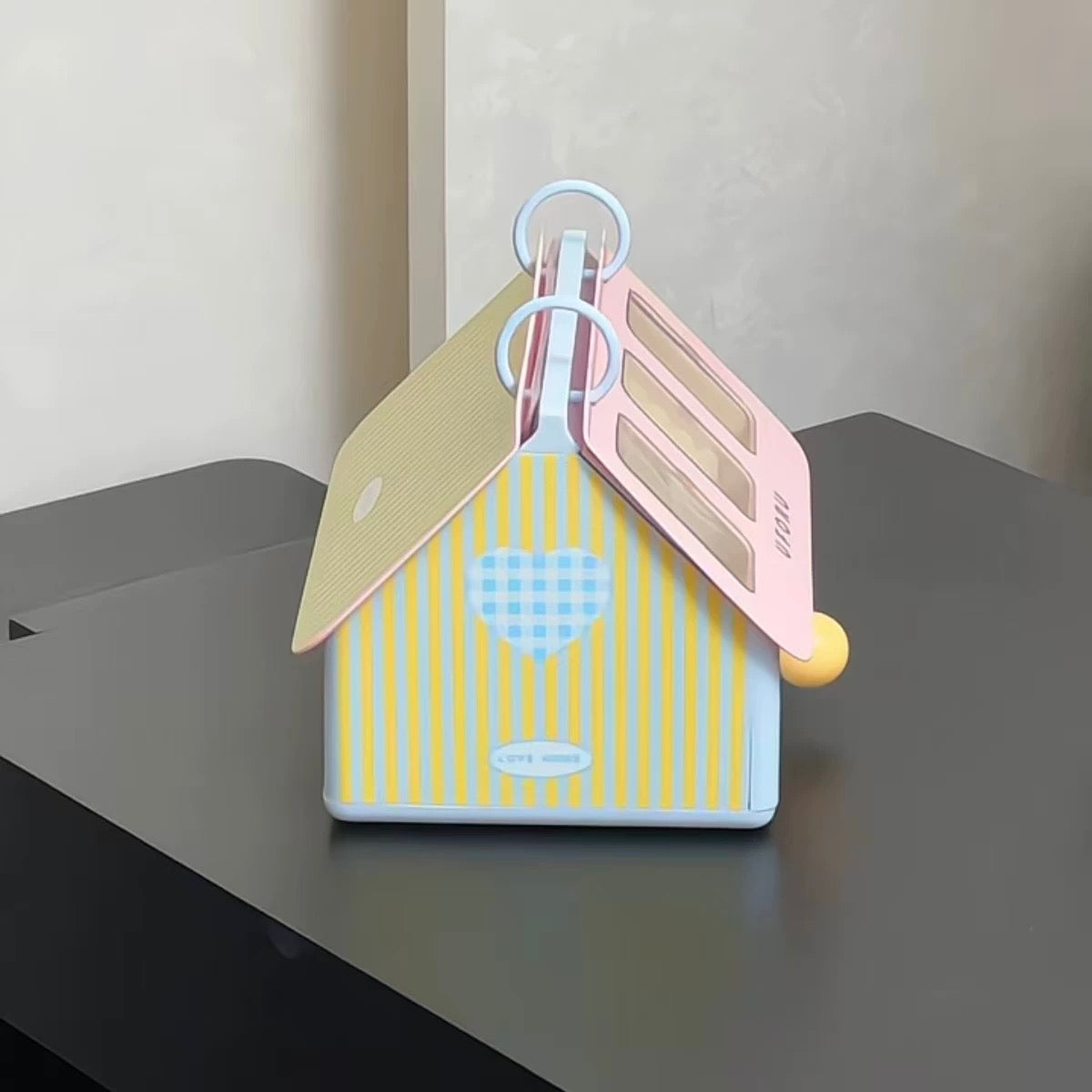 Decorative house-shaped object with a key on a dark surface