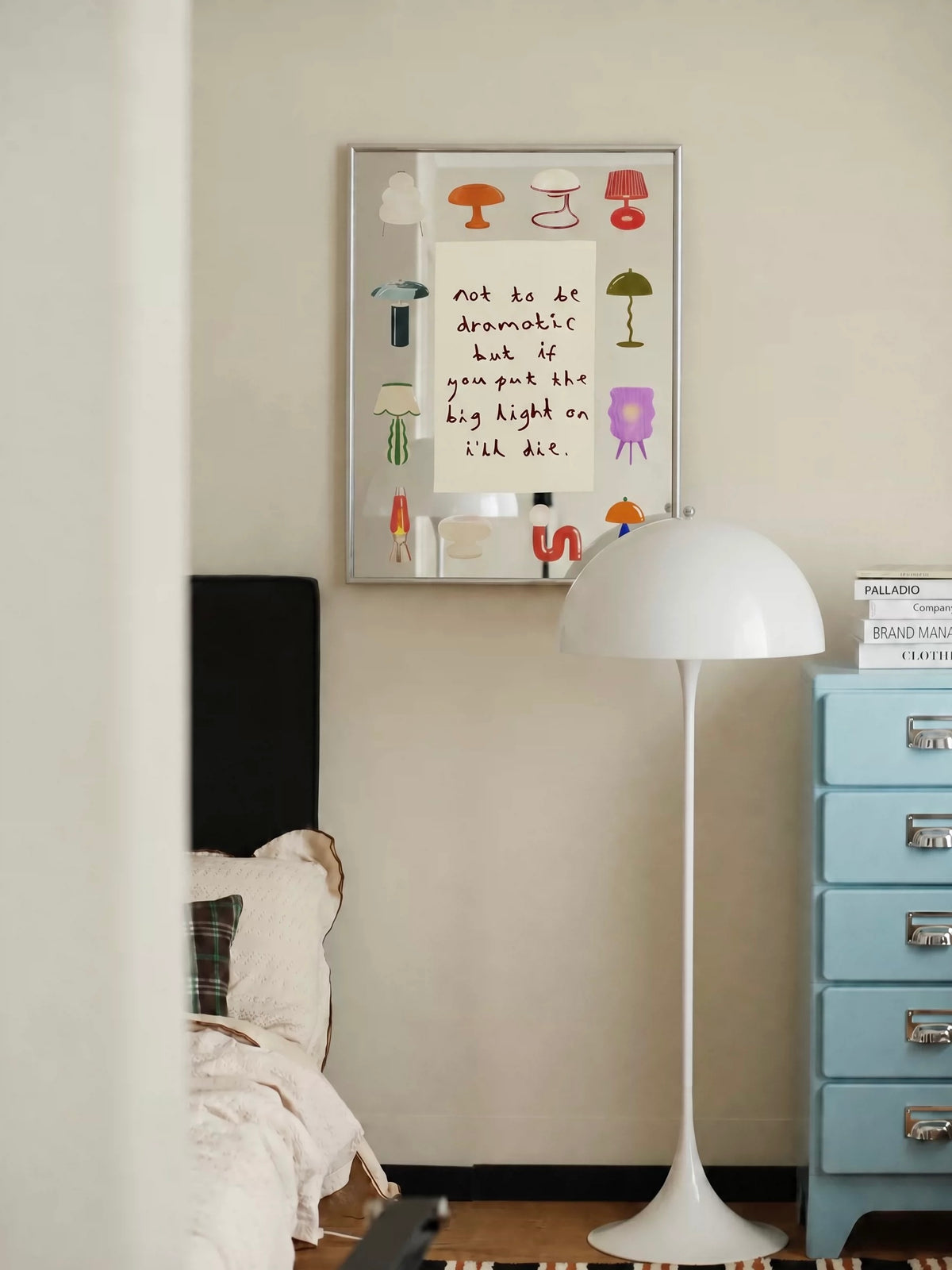 An illustrated lamp mirror hangs on the wall, with colorful lamp drawings around a central handwritten message.