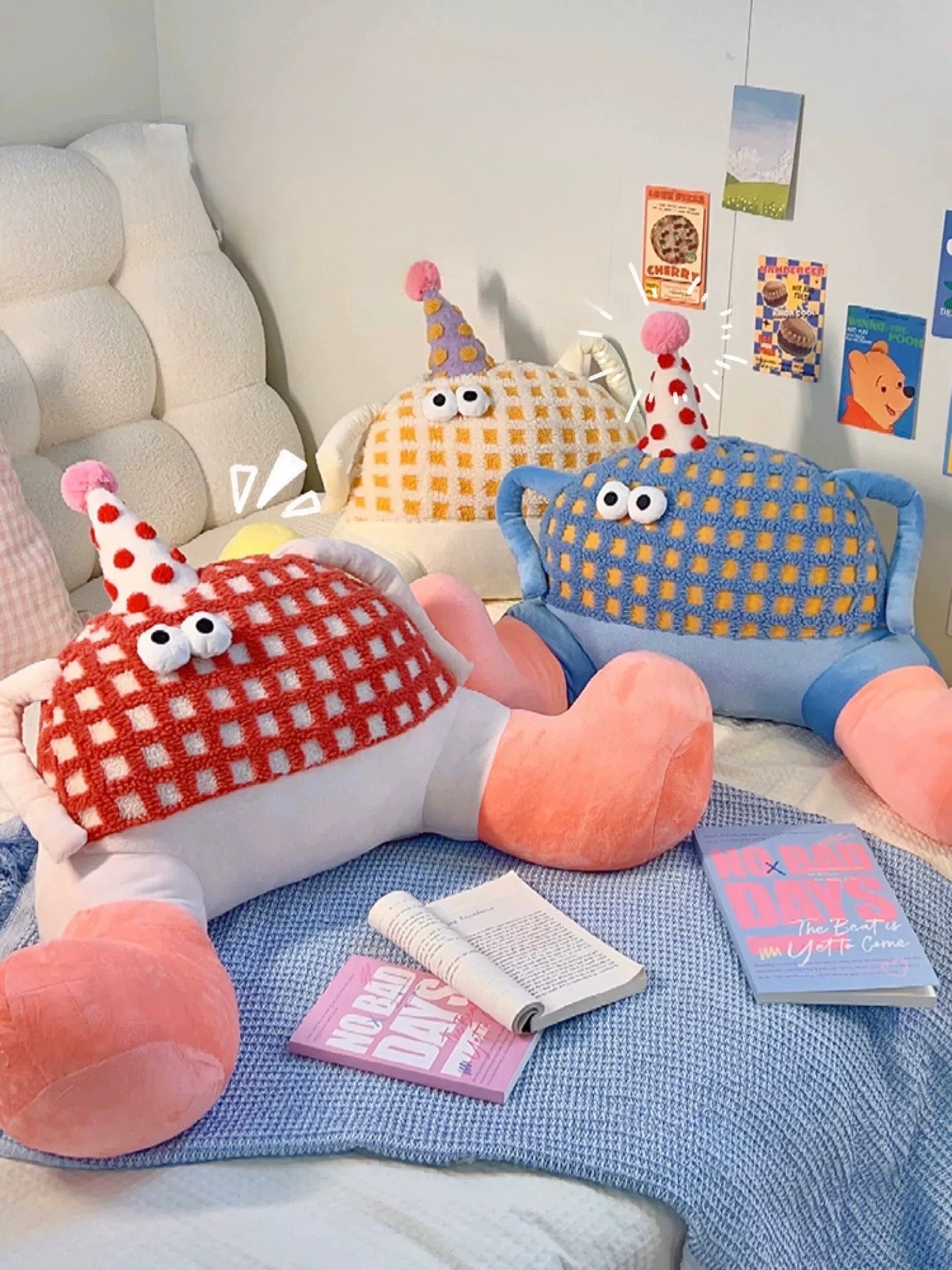 Plush toys on a bed with books and a blanket