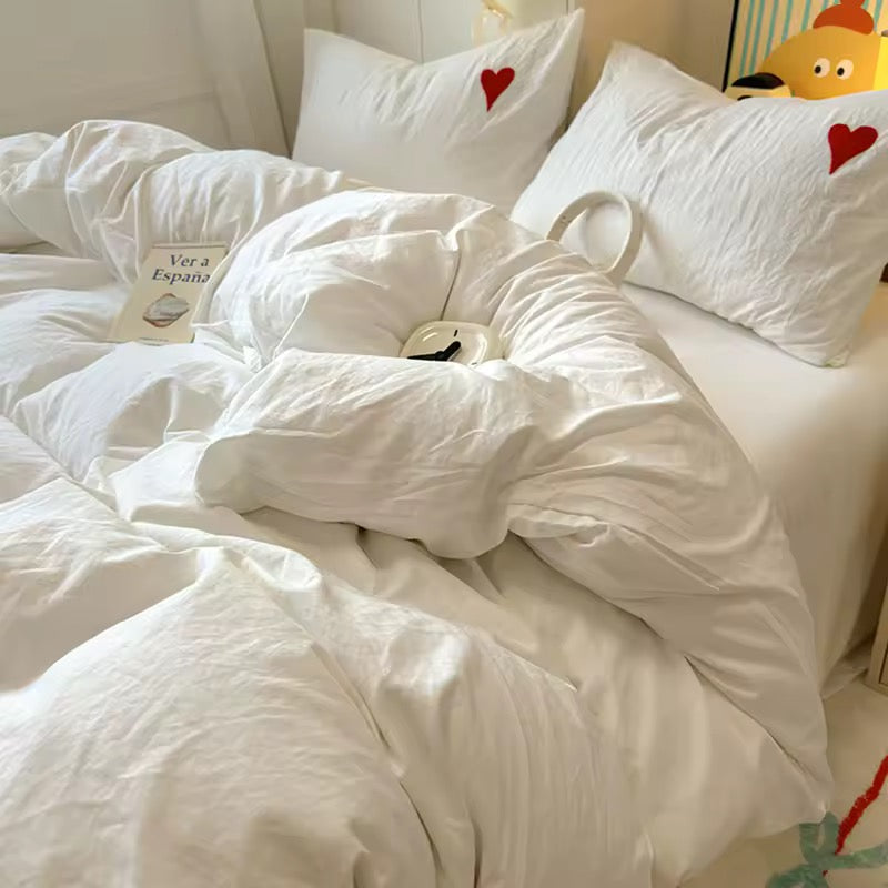 Pastel-themed bedroom with white heart bedding set and aesthetic wall art.