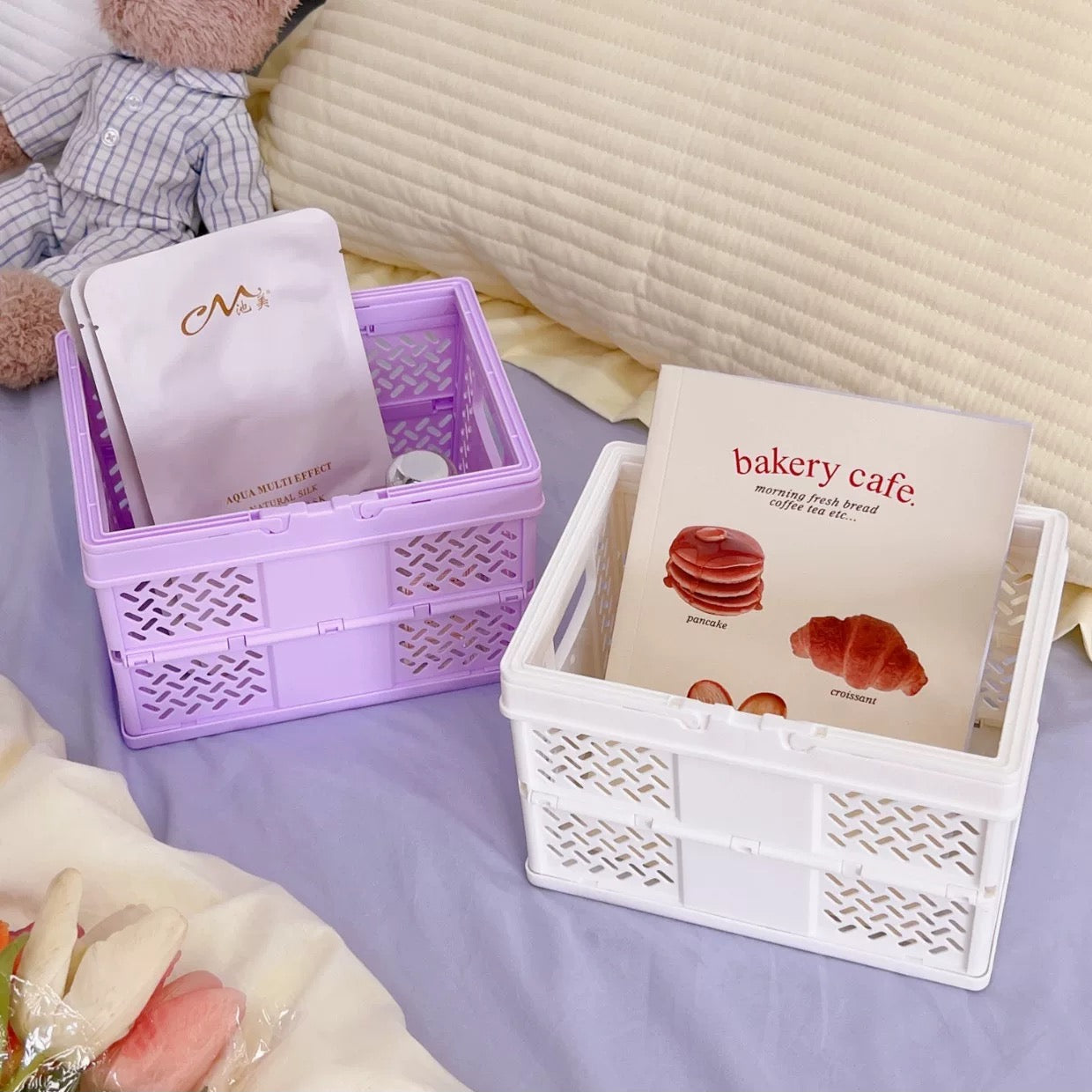 Pastel pink, green, and yellow folding baskets stacked on a coquette-style desk