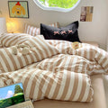 Neutral aesthetic bedroom featuring beige stripe bedding and teddy bear.